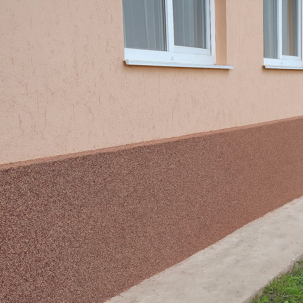 Персикова гладка штукатурка стіни і коричневий цоколь із мозаїчної крихти